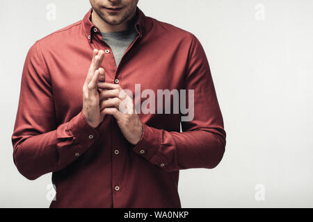 7/8 shot der Mann im braunen Hemd und gestikulierte mit Händen auf grau, menschliche Emotion und Expression Konzept isoliert Stockfoto