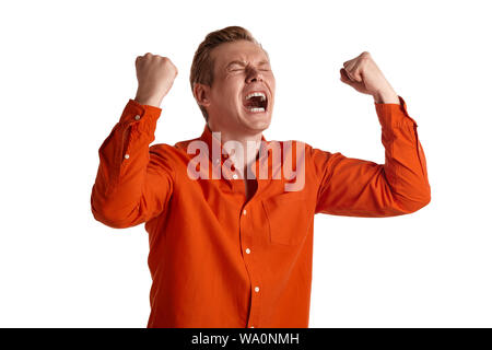 Nahaufnahme Porträt einer jungen aufgeregt Ingwer Person nür für diese in einem stilvollen orange Hemd, die wie er über etwas überglücklich ist, während sich isoliert auf weißem Posing Stockfoto