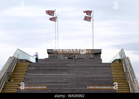 Ein Mann nimmt ein Bild vom Pier in Hastings, East Sussex. Stockfoto