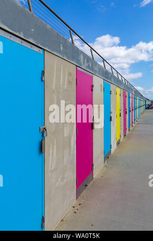 Bunten Badekabinen am Milford-on-Sea an einem warmen sonnigen Tag am Milford on Sea, Hampshire, UK im August Stockfoto