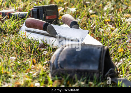 Zement Kellen und Tools auf Gras an der Baustelle. Stockfoto