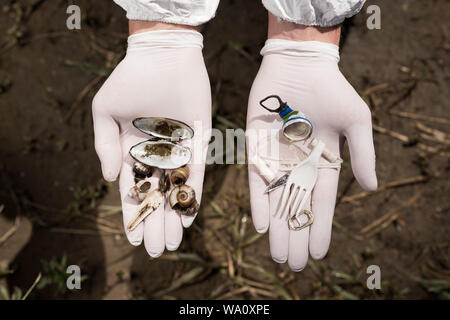 7/8-Ansicht von Ökologen in Latex Handschuhe Holding plastik Müll und Stockfoto