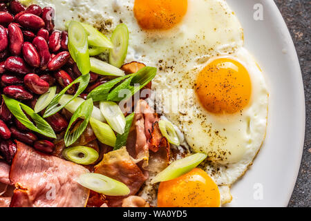 Englisches Frühstück mit Eiern, Speck, Bohnen und Zwiebel in iyoung weiße Platte Stockfoto
