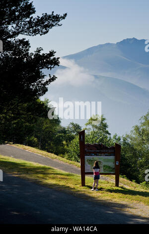 Eine Frau sieht ein Tourist Information Board am Col de Peguerre in den Französischen Pyrenäen. Stockfoto