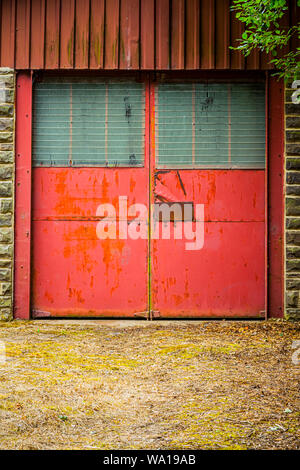 Roten Türen auf einem alten industriellen Werkstatt Gebäude oder in der Garage, in der Nähe der Consett, County Durham, England, Großbritannien Stockfoto