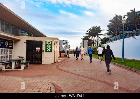 DURBAN, Südafrika - 12. AUGUST 2019: Touristen vorbei gehen die Rox Coffee Shop an der Promenade am Strand in Umhlanga Rocks, in der Nähe von Durban, KwaZul Stockfoto