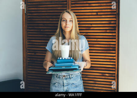 Schüler Mädchen mit einem Stapel Bücher Stockfoto