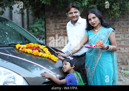 Familie stand vor einem Auto mit Pooja thali Stockfoto