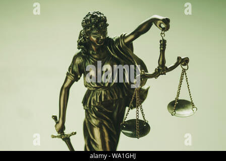 Statue des Gerichtshofs Holding aloft Skalen in ihrer Hand symbolische der Strafverfolgungsbehörden über einem hellgrünen Hintergrund Stockfoto