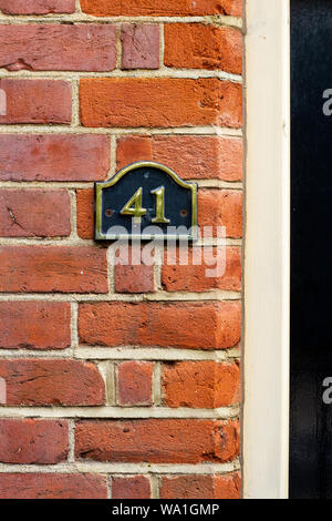 Haus Nummer 41 auf einem Black Metal auf einem Red brick wall Stockfoto