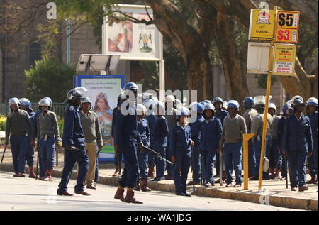 Harare, Simbabwe. 16 Aug, 2019. Polizisten stand Guard in Harare, Simbabwe, am 12.08.16., 2019. Geschäfte, Banken und Filialen in Simbabwes Hauptstadt Harare wurden am Freitag nach dem Hohen Gericht geschlossen eine geplante Demonstration von der oppositionellen MDC Allianz verboten. Schwer bewaffnete Polizisten im Central Business District patrouillierten Während einige an strategischen Bereiche in der Stadt stationiert waren, auch auf Afrika Platz der Einheit, wo die Demonstranten fällig waren, zu versammeln. Credit: Shaun Jusa/Xinhua Quelle: Xinhua/Alamy leben Nachrichten Stockfoto