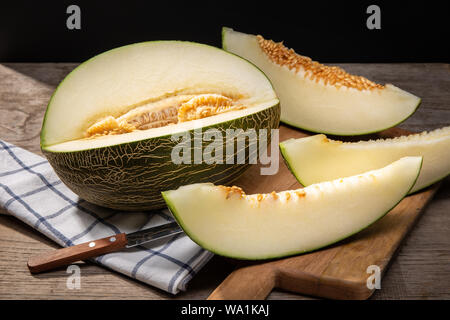 Frische Muskmelon mit Scheiben auf hölzernen Tisch. Cucumis Melo Stockfoto