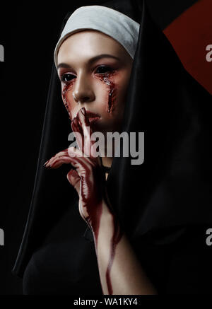 Dunkle Schönheit Nonne in Burka mit schwarzen Augen mit blutigen Flecken und Narben. Horror halloween Konzept der Hexe vom Teufel besessen Stockfoto