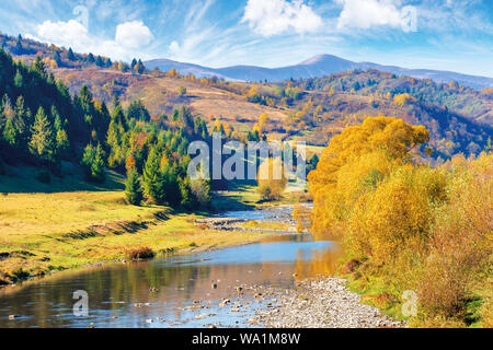 Schöne Landschaft im Herbst Farben. berg Fluss fließt durch das Tal. Bäume in Herbstfarben am Ufer. ridge mit hoher Gipfel im Fernen dist Stockfoto