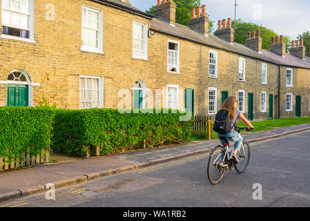Cambridge, UK - Juni 2019: junge Studentin Radfahrer Radfahren vor der traditionellen Wohnhäuser viktorianischen Häuser in Cambridge, Großbritannien. Stockfoto