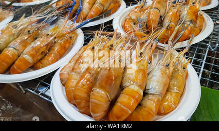 Straße Nahrungsmittel Thailand - gegrillte Garnelen, Gegrillte Garnelen und Meeresfrüchte auf weiße Platte zum Verkauf auf dem Markt. Stockfoto