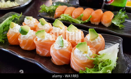 Overhead japanisches Sushi essen. Brötchen mit Lachs und Avocado, alle können Sie Menü essen, Sushi Roll japanisches Essen im Restaurant. Stockfoto