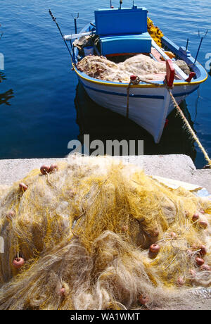 Griechenland. Lesbos. Kalloni Hafen. Kleine offene Fischerboot und Fischernetz auf Kai. Stockfoto