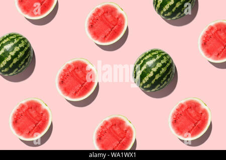 Muster mit Reife Wassermelone auf rosa Hintergrund. Ansicht von oben. Kopieren Sie Platz. Pop Art Design, kreative Sommer Konzept. Die Hälfte der Wassermelone in minimalen Flach Stockfoto