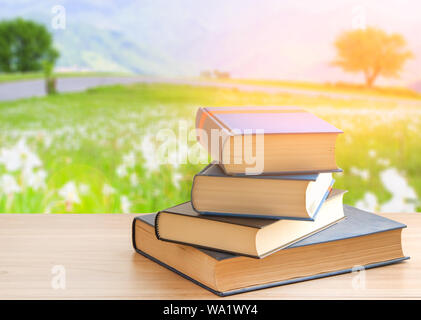 Buchen Sie Stapel oder Stoß von Buch auf hölzernen Tisch in Natur Hintergrund, zurück in die Schule. Stockfoto