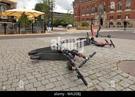 Elektrische VOI E-Scooter in der Fußgängerzone vor dem Rathaus am Hafen Platz in der schwedischen Stadt Helsingborg geworfen. Fußgänger dar. Stockfoto