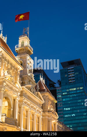 Ho Chi Minh City, Vietnam: Saigon Stadt Halle (People's Committee Head office) mit winkenden Vietnamesische flag & Vincom Center Türme im Hintergrund bei Nacht Stockfoto