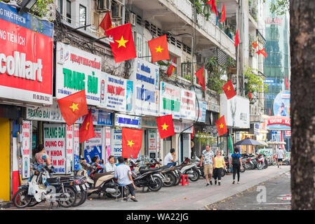 Ho Chi Minh, Vietnam: Tran Hung Dao Street mit vietnamesischen Flaggen am Vorabend der Wiedervereinigung Tag und Internationaler Tag der Arbeit eingerichtet. Stockfoto