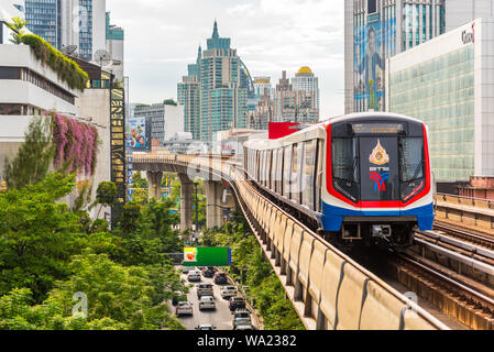 Bangkok - 25. Juni 2019: ein Zug fährt Nana BTS Station, mit Blick auf die modernen Gebäude in der Innenstadt und der Sukhumvit Road. Stockfoto