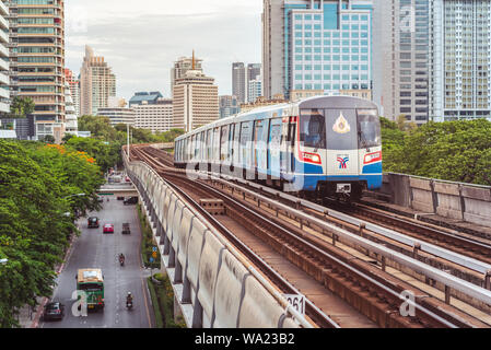 Bangkok - 25. Juni 2019: BTS-Zug fährt in Richtung Ratchadamri Station mit den Konturen der Innenstadt (Bang Rak Bezirk, Si Lom) im Hintergrund Stockfoto