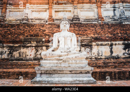 Buddha Statue auf alte Mauer Hintergrund in eine antike Stadt in Thailand. Mittelalterlichen buddhistischen Tempel Wat Yai Chai Mongkhon (Wat Yai Chaimongkol). Stockfoto