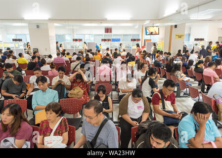 Bangkok - Juli 11, 2019: Die Menschen warten auf eine Verlängerung des Visums und Re-entry Permit in überfüllten Thailand beantragen. Stockfoto