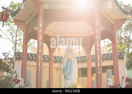 Ho Chi Minh City, Vietnam: Mutter Maria Statue im chinesischen Stil Arbor mit Sonnenstrahlen am Cha Tam Kirche (St. lit Franz Xaver Pfarrkirche). Stockfoto