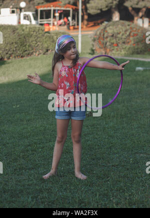 Kleines Mädchen ist das Spielen mit Ihrem Hula Hoop im Park Stockfoto