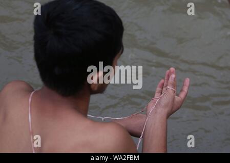 Kathmandu, Nepal. 15 Aug, 2019. Ein Mann hält die Heilige thread" Janai' Während der Gebete bei der Bank von Pashupatinath Tempel anlässlich von janai Purnima Festival. (Foto durch Archana Shrestha/Pacific Press) Quelle: Pacific Press Agency/Alamy leben Nachrichten Stockfoto