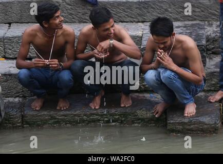 Kathmandu, Nepal. 15 Aug, 2019. Anhänger Angebot Gebete Holding heilige Gewinde an der Bank von Pashupatinath Tempel anlässlich von janai Purnima Festival. (Foto durch Archana Shrestha/Pacific Press) Quelle: Pacific Press Agency/Alamy leben Nachrichten Stockfoto