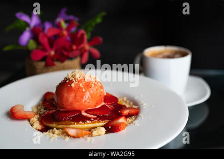 Frisch hausgemachten Pfannkuchen Erdbeer Crumble auf Weiß Dessertteller Stockfoto