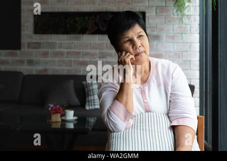 Senior Asien Frau denken und seitlich suchen, Denken und Fragen Stockfoto