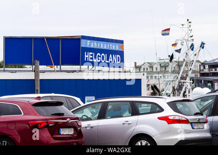 09. August 2019, Schleswig-Holstein, Büsum: Autos Park vor einem Fahrkartenschalter im Hafen von Büsum. Einmal am Tag gibt es mit der Fähre nach Helgoland. (Dpa' Büsum ist "letzte Ausfahrt nach Helgoland'') Foto: Frank Molter/dpa Stockfoto