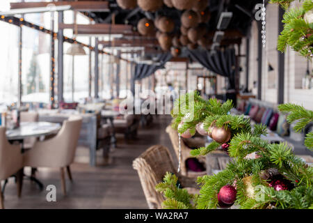 Nahaufnahme Weihnachten Neujahr Dekoration, Tannenzweigen mit glänzenden festlichen Spielzeug golden und rosa Kugeln auf dem Hintergrund der inneren Veranda moderne rest Fichte Stockfoto