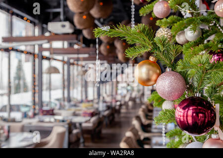 Nahaufnahme Weihnachten Neujahr Dekoration, Tannenzweigen mit glänzenden festlichen Spielzeug golden und rosa Kugeln auf dem Hintergrund der inneren Veranda moderne rest Fichte Stockfoto