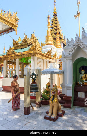 Yangon, Myanmar-May 6 2014: Frau läutenden Glocke in der Shwedagon Pagode. Die Pagode ist der heiligste in allen von Myanmar. Stockfoto