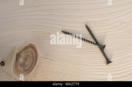Hintergrund, zwei Bau Schrauben liegen auf einem Holzbrett Stockfoto