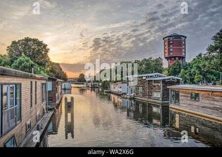 Zwolle, Niederlande, Juli 26; 2019: spektakulären Sonnenuntergang Himmel über almelose Kanal mit Hausbooten und einen Wasserturm, Apartments umgewandelt Stockfoto