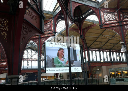 LCD-Werbung in Dach Bolton Marktplatz umgewandelt in ein modernes Einkaufszentrum während der Viktorianischen Schmiedearbeiten der ursprünglichen Markthalle Sicherungsring Stockfoto