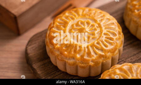 Runde frisch gebackene Mond kuchen Gebäck - Chinesische moonckae für Mid-Autumn Moon Festival auf hölzernen Hintergrund und Serviertablett, Nahaufnahme, kopieren Raum Stockfoto