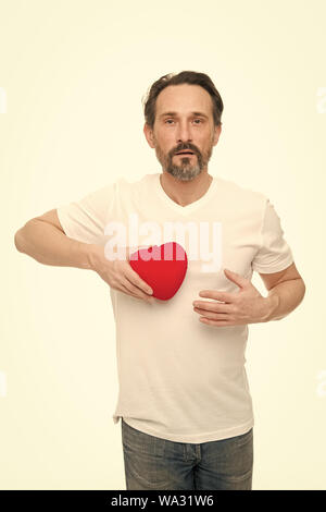 Herz-Attribut von Valentine. Herz Geschenk präsentieren. Gruß aus ehrlichem Herzen. Man bärtige Hipster halten Herz. Romantischer Kerl verlieben. Valentines Tag feiern. Liebe und romantische Gefühle Konzept. Stockfoto