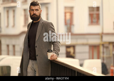 Man bärtige hipster Kaffee trinken Pappbecher. Noch ein Schluck Kaffee. Stadt Lebensstil. Geschäftsmann gepflegt aussehen genießen Sie Kaffee Pause aus Business Center im städtischen Hintergrund. Entspannen und erholen Sie sich. Stockfoto