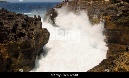 Meer mit Wellen spashing zu den beiden Felsen auf beiden Seiten. Weiß big Spritzwasser, Felsformationen Stockfoto