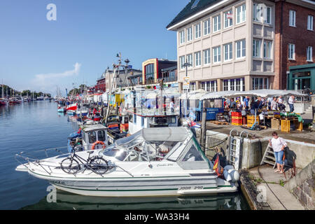 Alter Strom Warnemunde Hafenkanal, Strandpromenade mit verankerten Booten und Bars, Alter Kanal, Rostock Deutschland Stockfoto