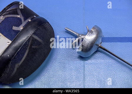 Fechten Maske und Folie auf blauem Boden. Stockfoto